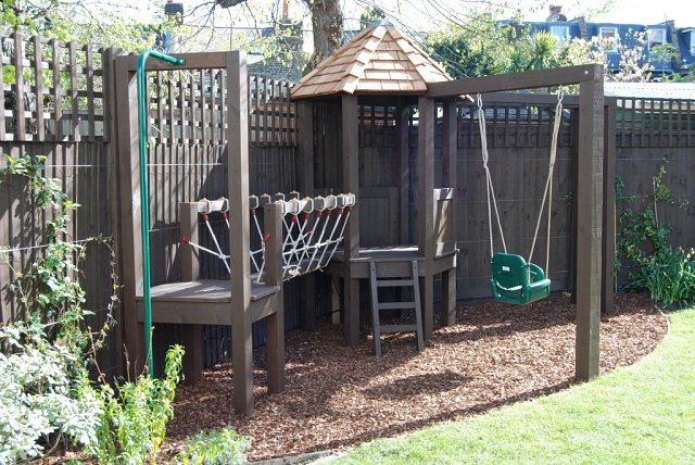 Playframe with rope bridge, play house, monkey bars, swing, fireman's pole